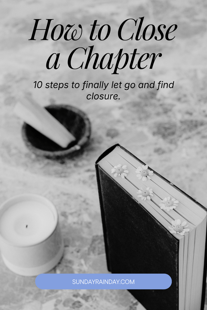 Black and white flat lay of an upright closed book with pressed daisies in its pages, a candle, and incense, titled How to Close a Chapter in Your Life
